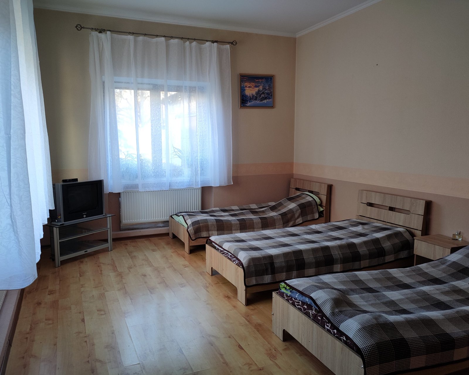 Кімната з трьома ліжками, телевізором та вікном у центрі Рестарт+