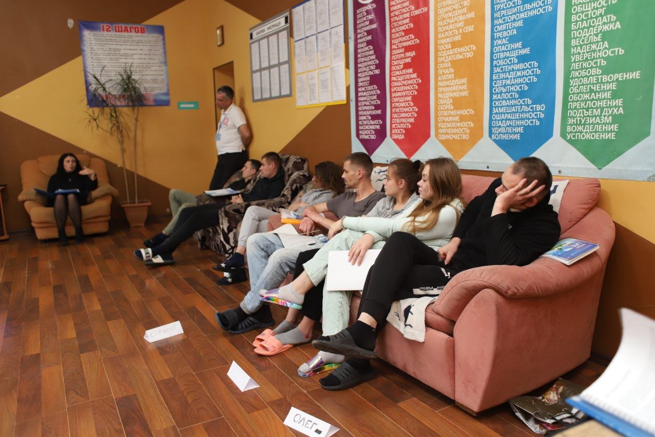 Групова терапія — пацієнти на диванах слухають психолога в центрі Рестарт+