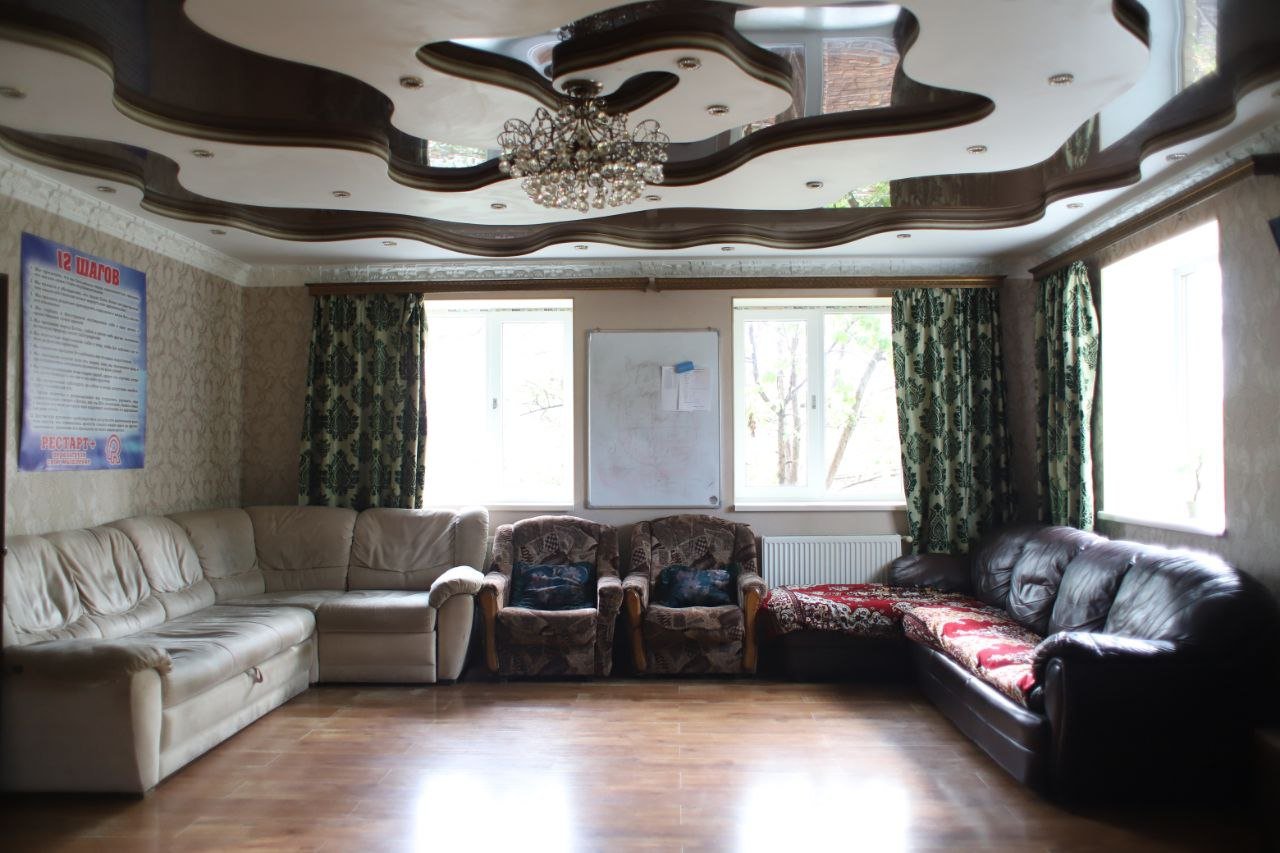 Просторный зал для групповых занятий с мягкой мебелью и большими окнами