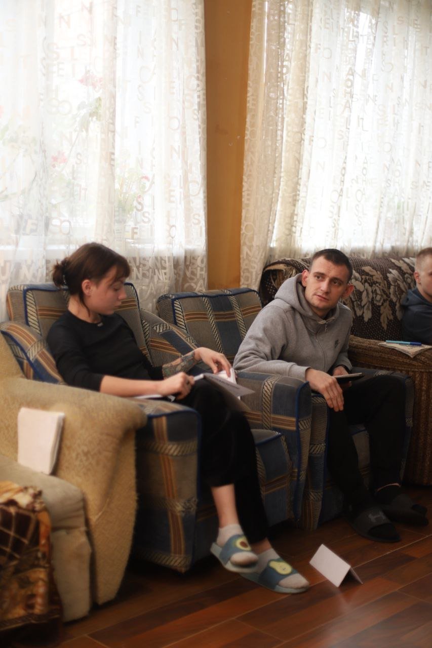 Люди сидять на диванах з документами під час зустрічі у Рестарт+