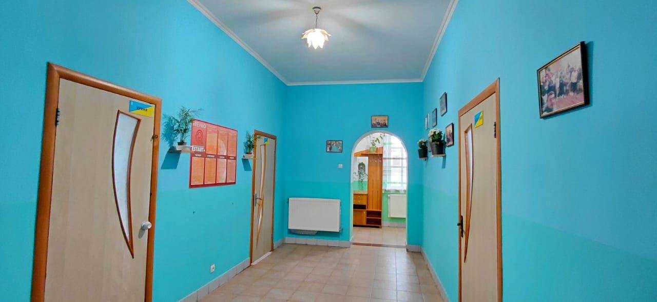 Коридор з блакитними стінами та дерев'яними дверима у центрі Рестарт+